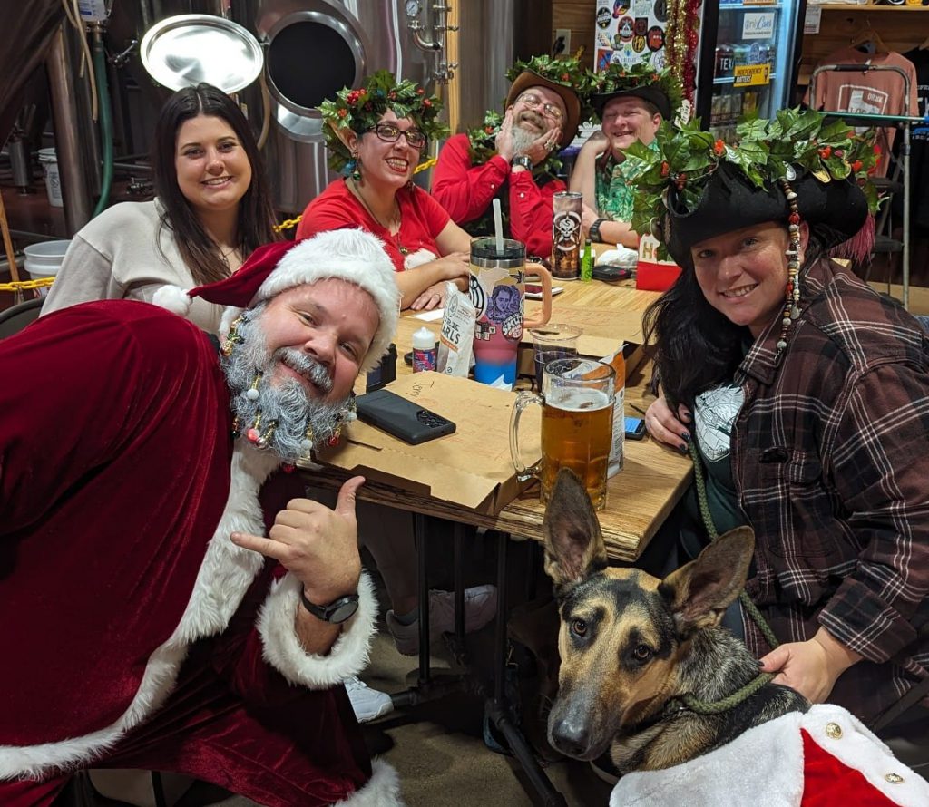 Friends sitting around a table dressed up for Christmas. 