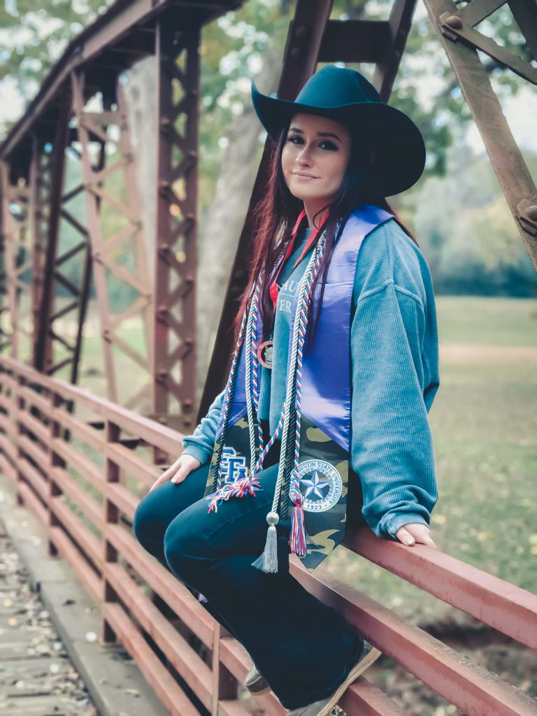 Girl in cowboy hat on fence. 